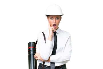 Wall Mural - Young architect caucasian woman with helmet and holding blueprints over isolated background surprised and shocked while looking right