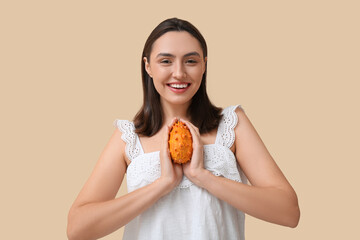 Poster - Beautiful young woman with yellow kiwano on beige background