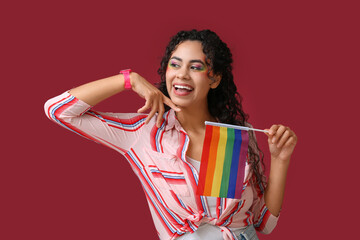 Poster - Happy African-American woman with rainbow flag on red background. LGBT concept