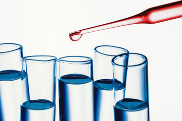 Wall Mural - Virus vaccine research laboratory background. Red fluid pipette drop into glass flask. Blood color test transparent liquid. Empty copy space epidemic background. Covid-19 coronavirus spread texture.