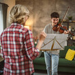 © Miljan Živković - Young man learn how to play violin under instruction mature professor
