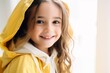 Portrait of a cute little girl wearing a yellow raincoat.