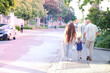 man and woman with child, happy family together walks along city street, blurred overexposed image, concept of family serene happiness, cherishing life's moments, urban landscape