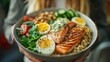 A person holding a bowl of food with salmon, eggs and vegetables, AI