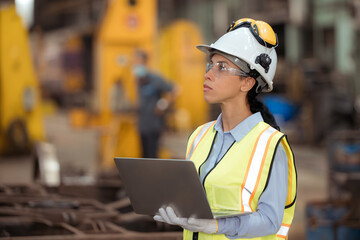 Portrait of railway technician worker in safety vest and helmet working with blueprint at train repair station