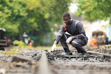 Portrait of a railway engineer on the tracks of a train in station platform.