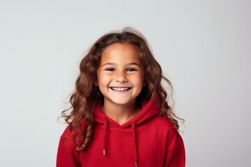 Wall Mural - Portrait of a smiling little girl in red hoodie against grey background