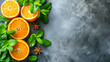 A close up of four oranges and a bunch of mint leaves. The oranges are cut in half and the mint leaves are scattered around them. Concept of freshness and health, as the combination of oranges