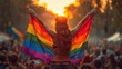 Woman proudly holds rainbow flag in front of cheering crowd