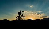 Fototapeta Natura - A person who goes for morning exercise on his bike witnesses the sunrise and creates new routes.