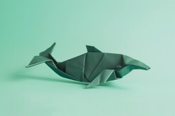 origami whale on pastel green background