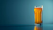Refreshing beer glass with frothy head on blue background