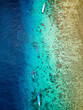 Aerial view of traditional outrigger type boats with snorkelers and swimmers over a tropical coral reef in a clear, warm ocean