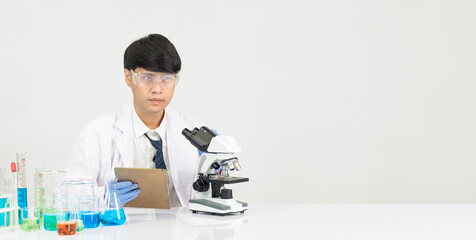 Wall Mural - Portrait asian man student scientist doctor gown one person sti in lab looking hand holding test tube chemist. caused by mixing reagents in scientific research laboratories and microscope on table