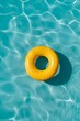 yellow swimming pool ring float in blue water. concept color summer. vertical photo