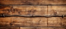 A Brown Barbed Wire Fence Is Hanging On A Wooden Wall Made Of Hardwood Planks With A Wood Stain Finish. The Wall Is Constructed Using Plywood Building Material In A Rectangular Pattern