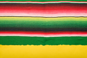Wall Mural - Yellow scrap paper on colorful serape. Empty template for text, Cinco de Mayo background.