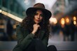 Portrait of a beautiful young woman in a hat sitting on a bench in the city at night