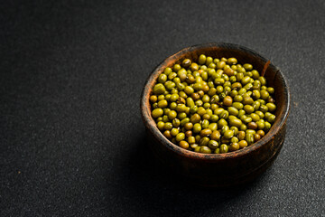 Wall Mural - Close-up of mung beans in a ceramic bowl. Superfood On a dark concrete background.