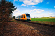Regionalbahn mit grünem Feld , Wolken und Windkraft im Hintergrund - Train on the Railway -  Ecology - Railroads - Eisenbahn - Zug - Lok - Lokomotive - Regionalbahn - Background - Concept 