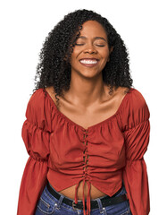 Wall Mural - African American woman in studio setting laughs and closes eyes, feels relaxed and happy.