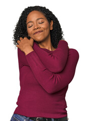 Wall Mural - African American woman in studio setting hugs, smiling carefree and happy.