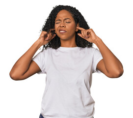 Wall Mural - African American woman in studio setting covering ears with fingers, stressed and desperate by a loudly ambient.