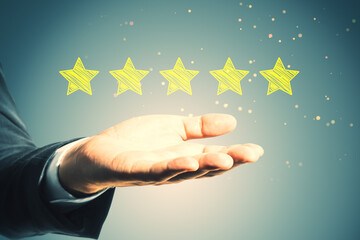 Close up of businessman hand holding 5 star rating on blurry background. Customer service and excellent feedback concept.