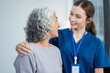 young caregiver assists her elderly woman patient at a nursing home. senior woman is assisted by a nurse at home.