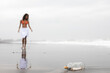© Westend61 - Message in glass bottle with woman on wet sand at beach