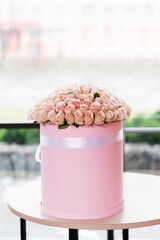 Wall Mural - Beautiful large bright bouquet of pink roses flowers in a round box on the table