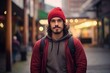 Portrait of a handsome young man with backpack and red hat in the city