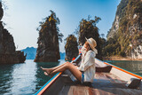Fototapeta Miasto - Traveler asian woman relax and travel on Thai longtail boat in Ratchaprapha Dam at Khao Sok National Park Surat Thani Thailand