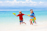 Fototapeta Na ścianę - Child with toy water gun. Kids vacation beach fun.