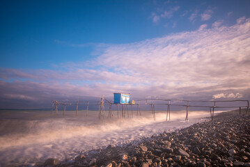 Wall Mural - wooden fishing piers lying on the sea of Marmara cloudy weather sunset hours while the waves hit the beach
