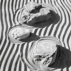 Wall Mural - A black and white photo of a sand sculpture with rocks. Generative AI.
