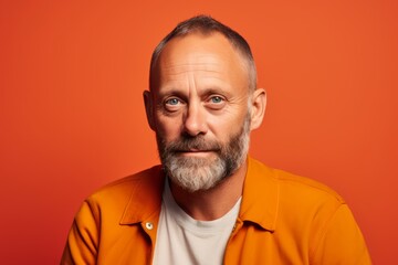 Wall Mural - Portrait of a surprised mature man looking at camera on orange background