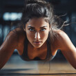 Portrait of a beautiful young woman doing push-ups in the gym