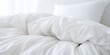 White bedding including pillows duvet and duvet cover on a disheveled bed
 