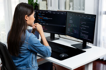 Young Asian IT developer looking online information on pc for beautiful pose with coding program data of website application, wearing jeans shirt. surround by safety analysis two screens. Stratagem.