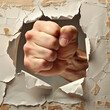 © Image-Love - A fist is shown through a hole in a wall. The fist is clenched and the hand is extended. Concept of anger and frustration