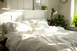 © youriy - Sunlit cozy bedroom with unmade bed and plants