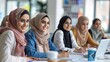 © AdriFerrer - Group of smiling women with hijabs in a collaborative setting.