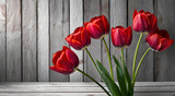 Fototapeta Tulipany - Czerwone tulipany. Bukiet wiosennych kwiatów. Tło deski