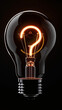 A single light bulb, with a bright, glowing filament that is shaped like a question mark, brand new and glowing brightly, floating isolated against a deep, solid black background.