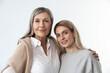 Mother and daughter standing together on a white background