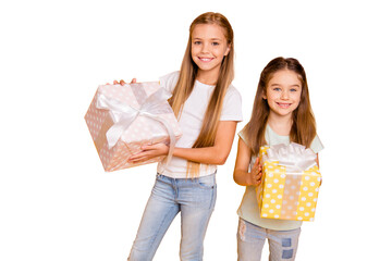 Wall Mural - Portrait of two nice cute sweet attractive cheerful cheery pre-teen girls holding in hands large boxes isolated over bright vivid shine yellow background