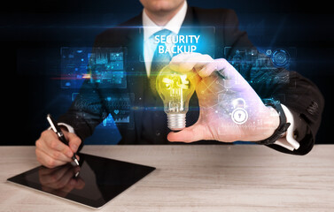 Poster - Businessman holding a light bulb, online security concept