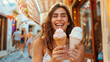 The portrait of an attractive and happy young woman with curly hairstyle is eating an ice cream cones in her hand at gelateria at hot summer day. Italy travel, female tourist enjoys gelato