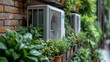   Two AC units resting atop a brick wall with various potted plants nearby